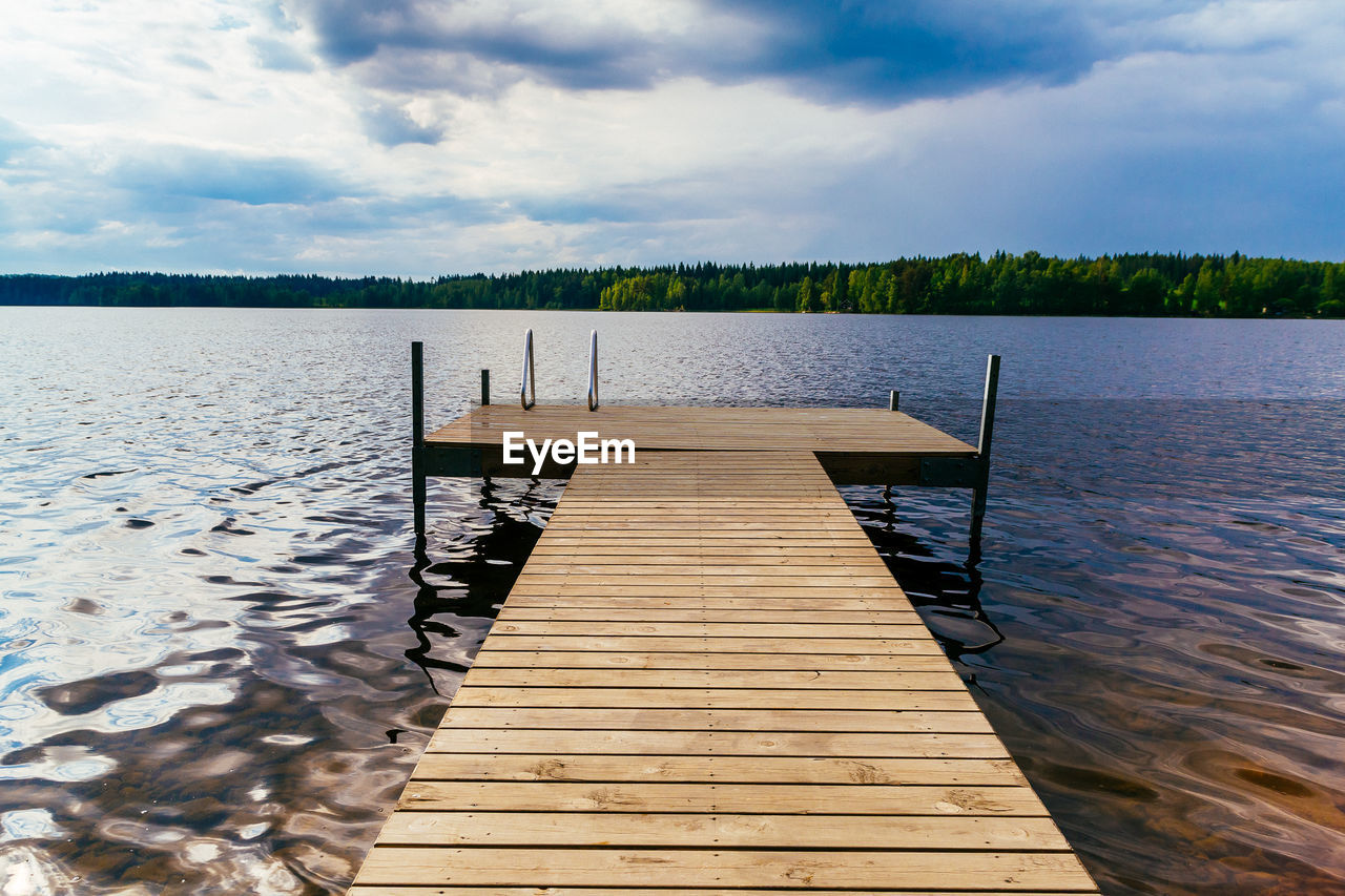 Jetty in lake against sky