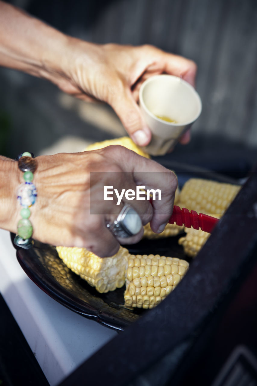 Woman preparing corn on cobs, sweden