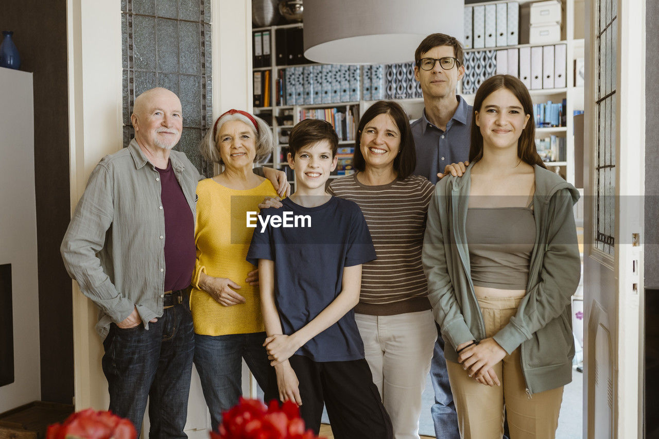 Portrait of smiling multi-generation family standing together at home