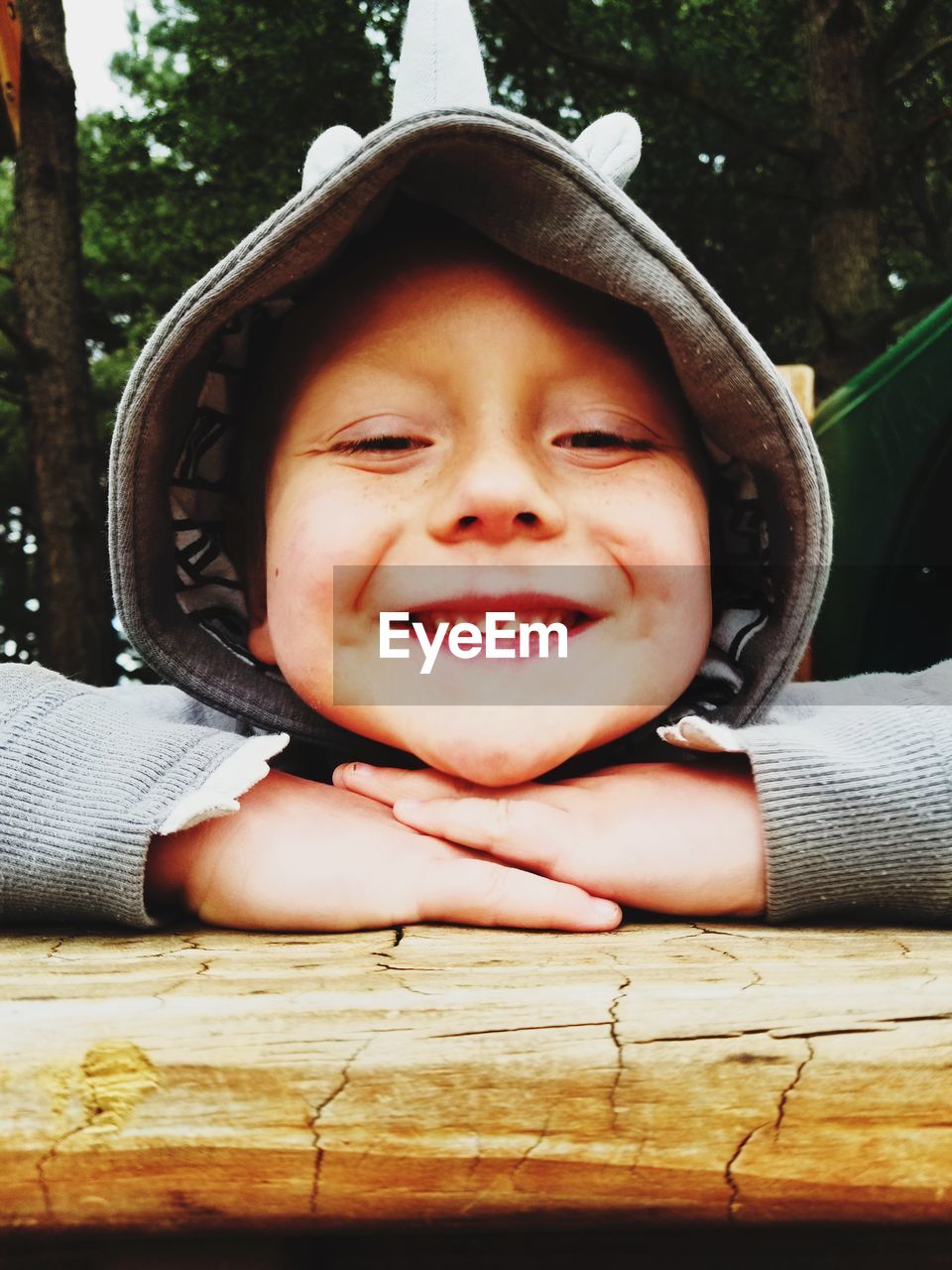 Close-up portrait of smiling boy on wooden table