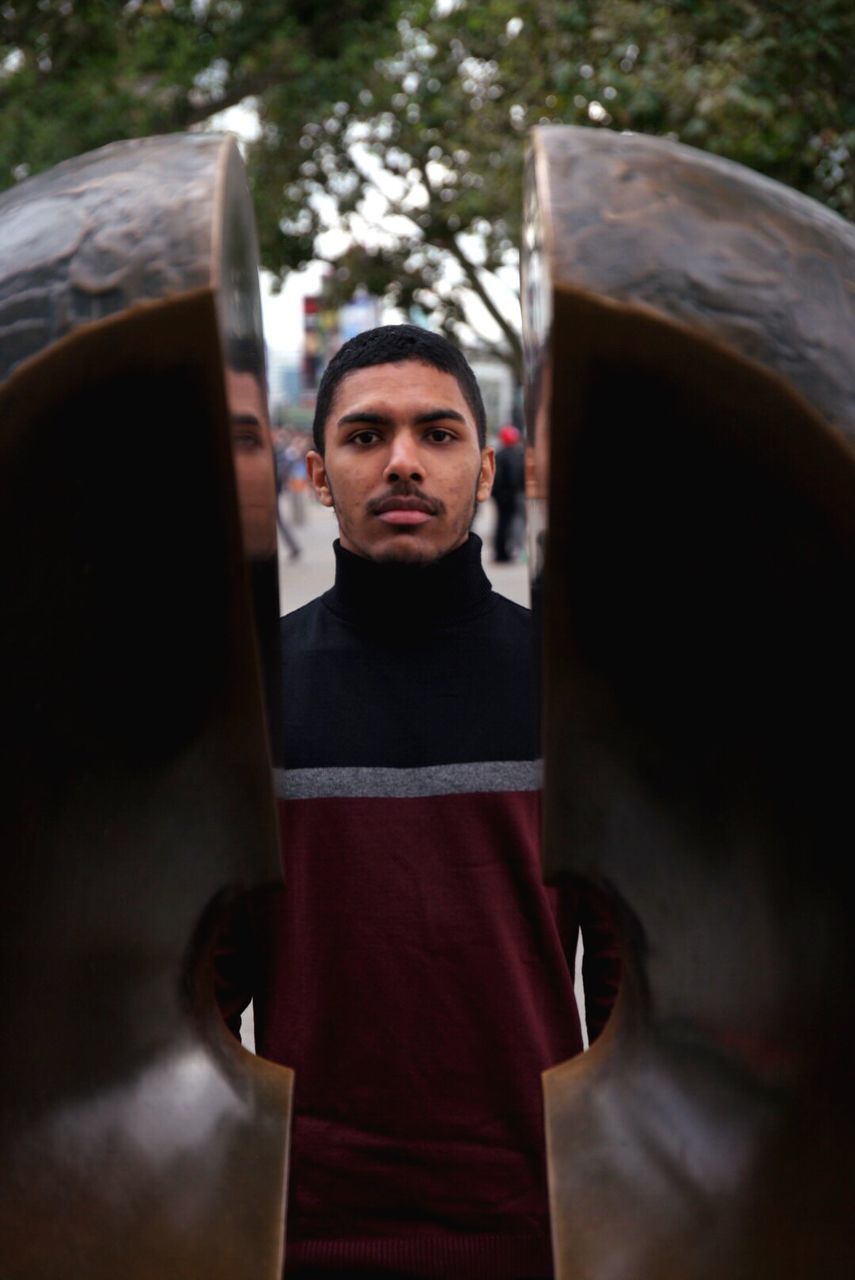 Portrait of man standing against wooden structure