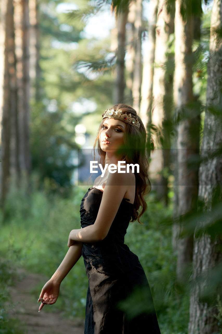 Side view of young woman in forest