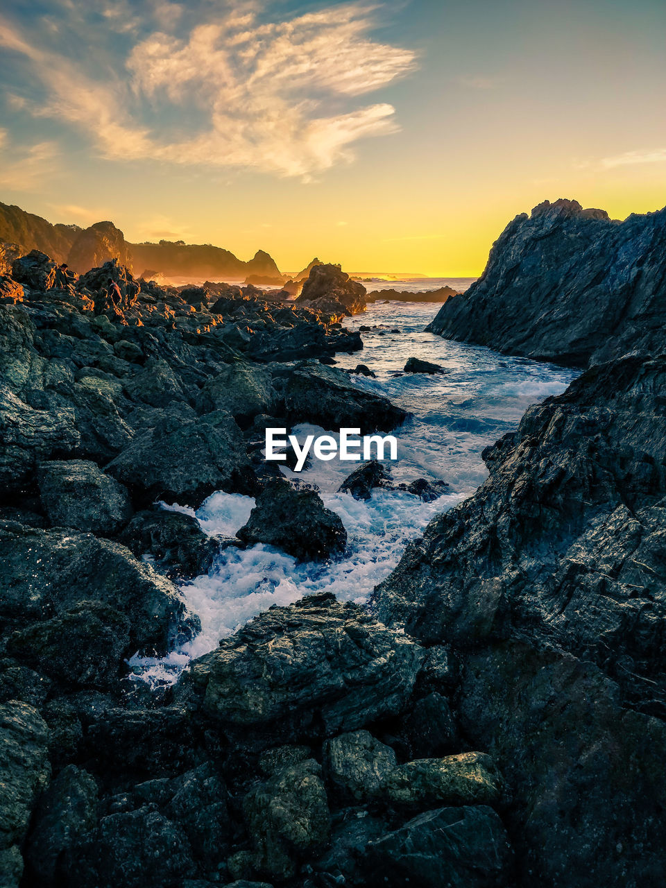 ROCKS IN SEA AGAINST SKY DURING SUNSET