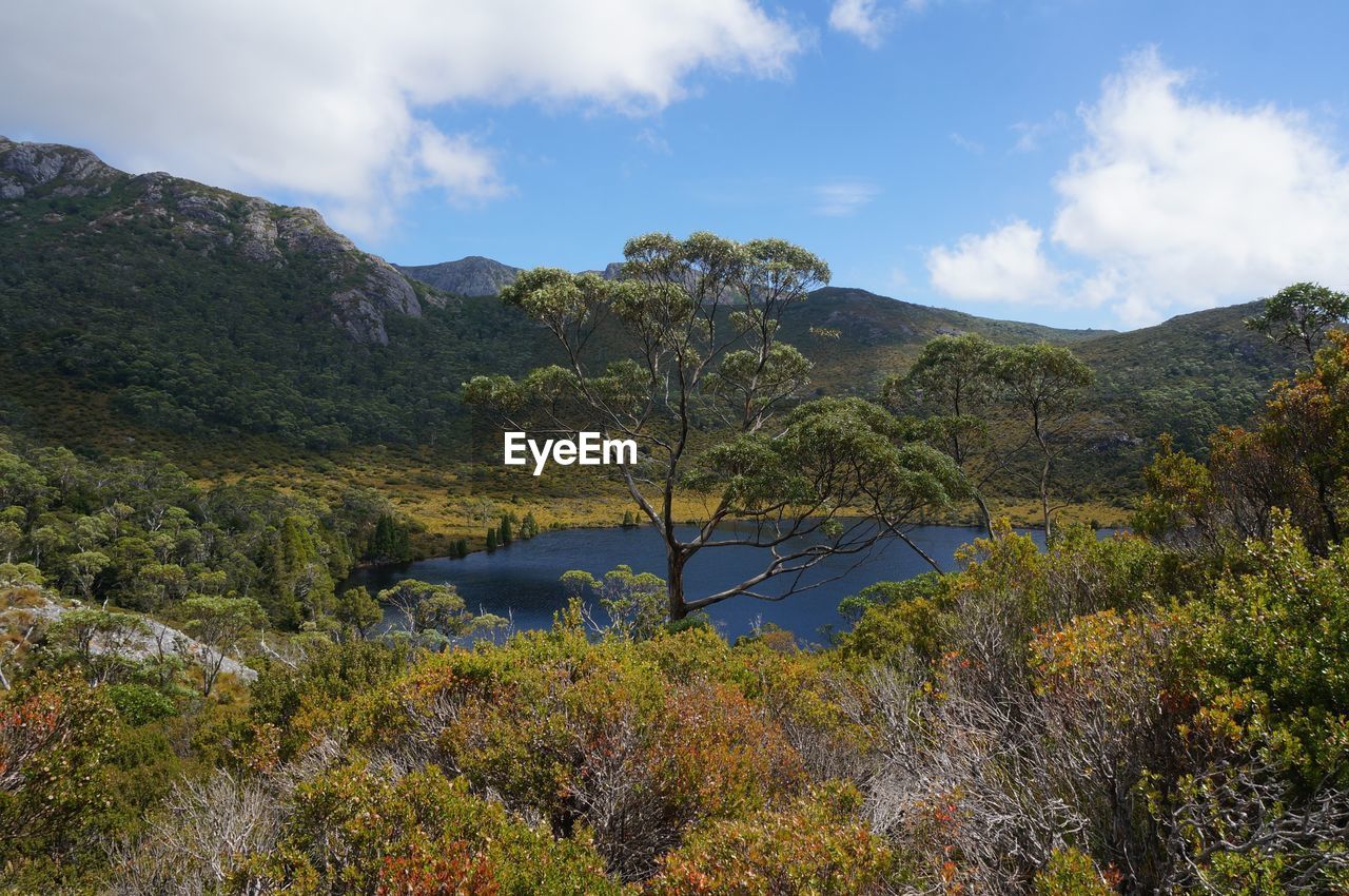 Scenic view of lake by mountain against sky