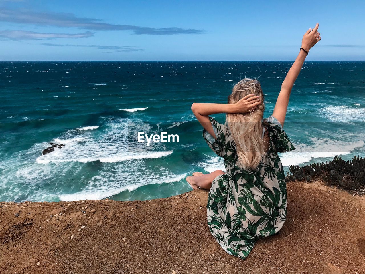 Rear view of woman sitting at beach