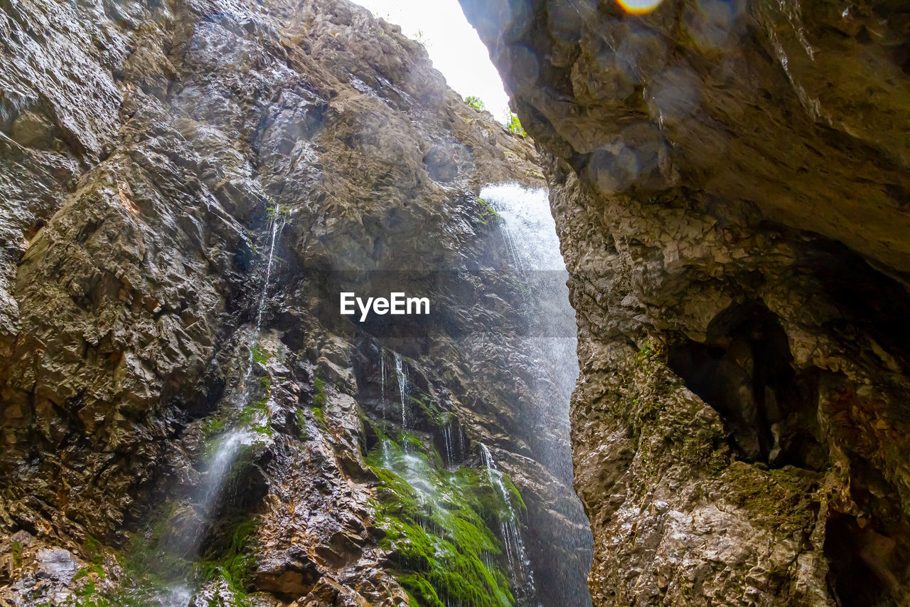 LOW ANGLE VIEW OF WATERFALL ON ROCKS