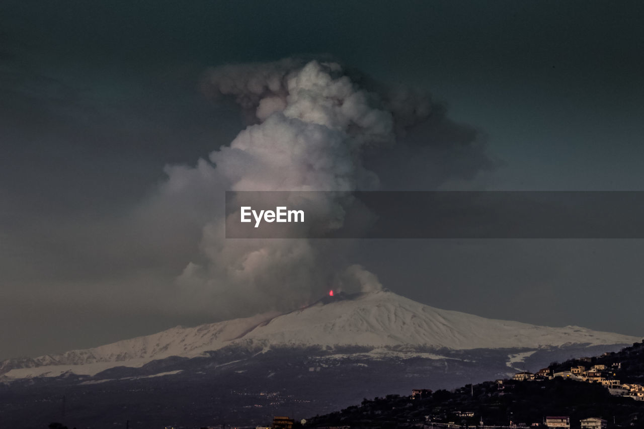 Smoke emitting from volcanic mountain against sky