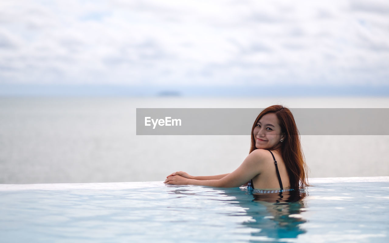 Portrait of young woman swimming in sea