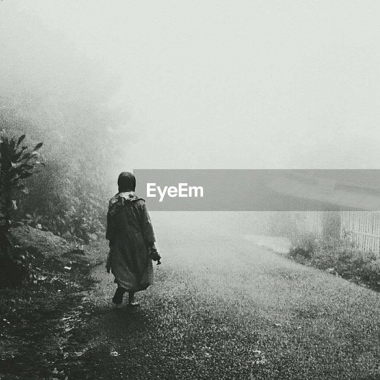 REAR VIEW OF WOMAN STANDING IN PARK