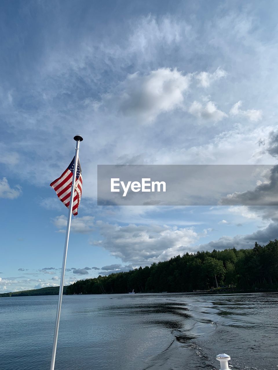 RED FLAG ON RIVER AGAINST SKY