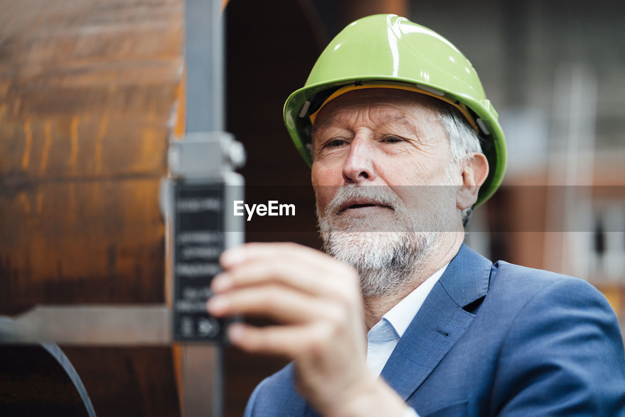 Male manager measuring metal with caliper in warehouse