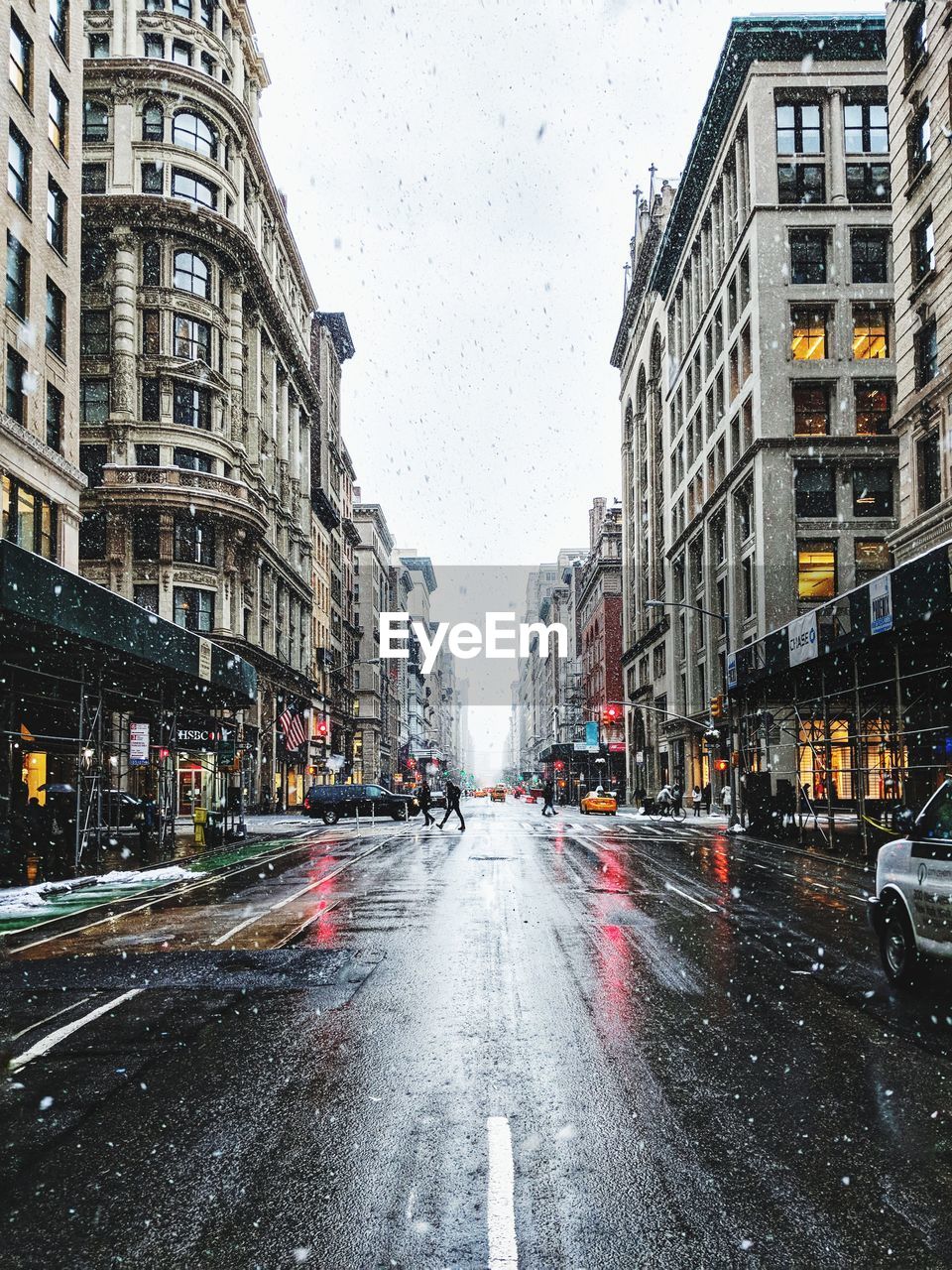 Wet street in city during snowfall