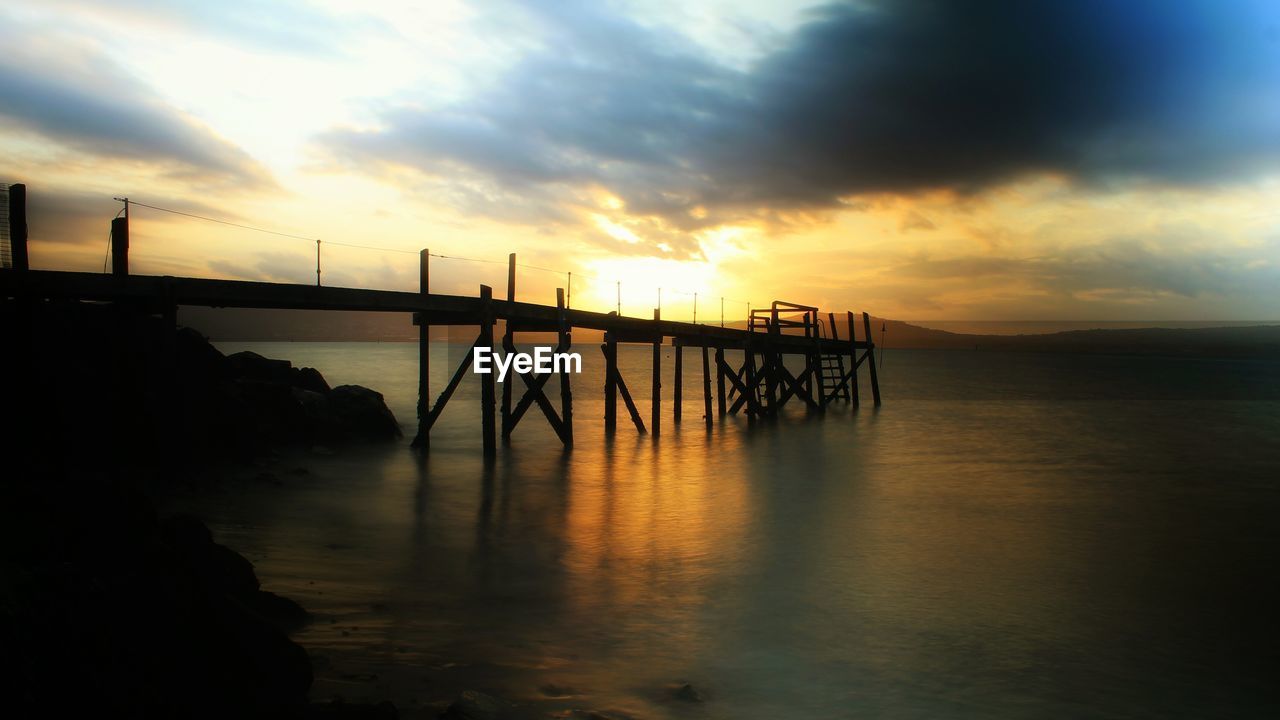 Scenic view of pier at sunset