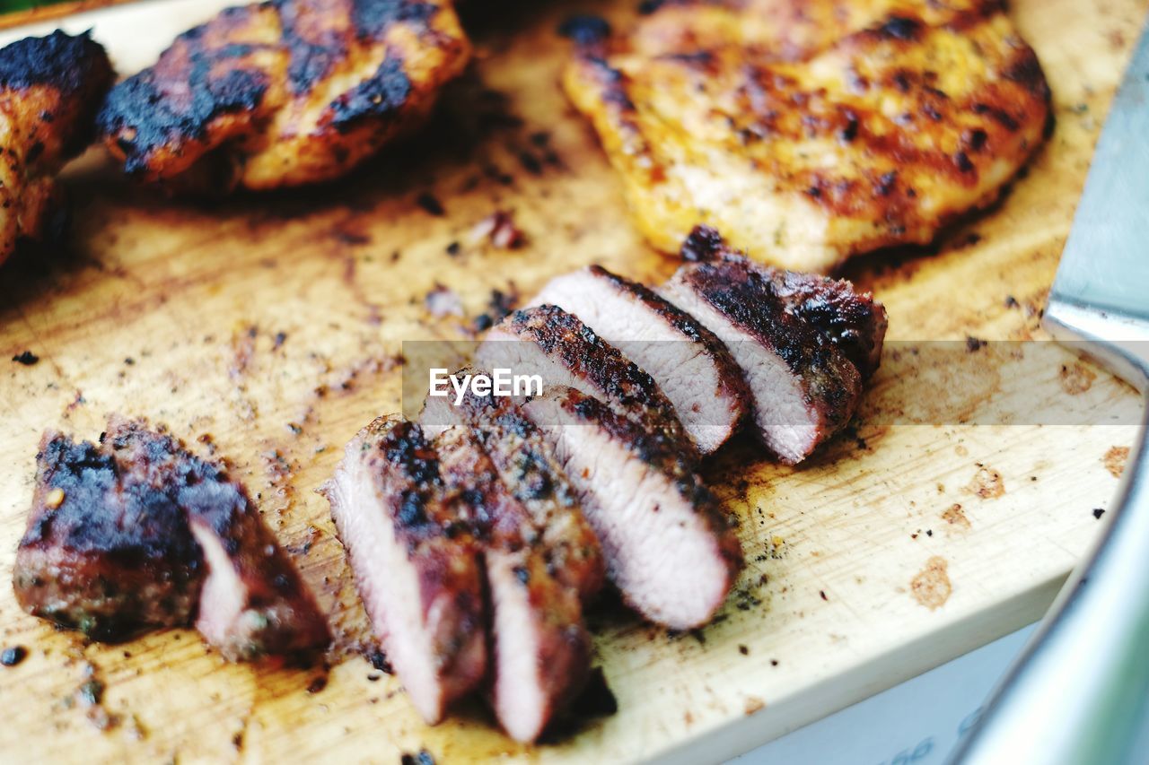 High angle view of roasted sliced meat on cutting board