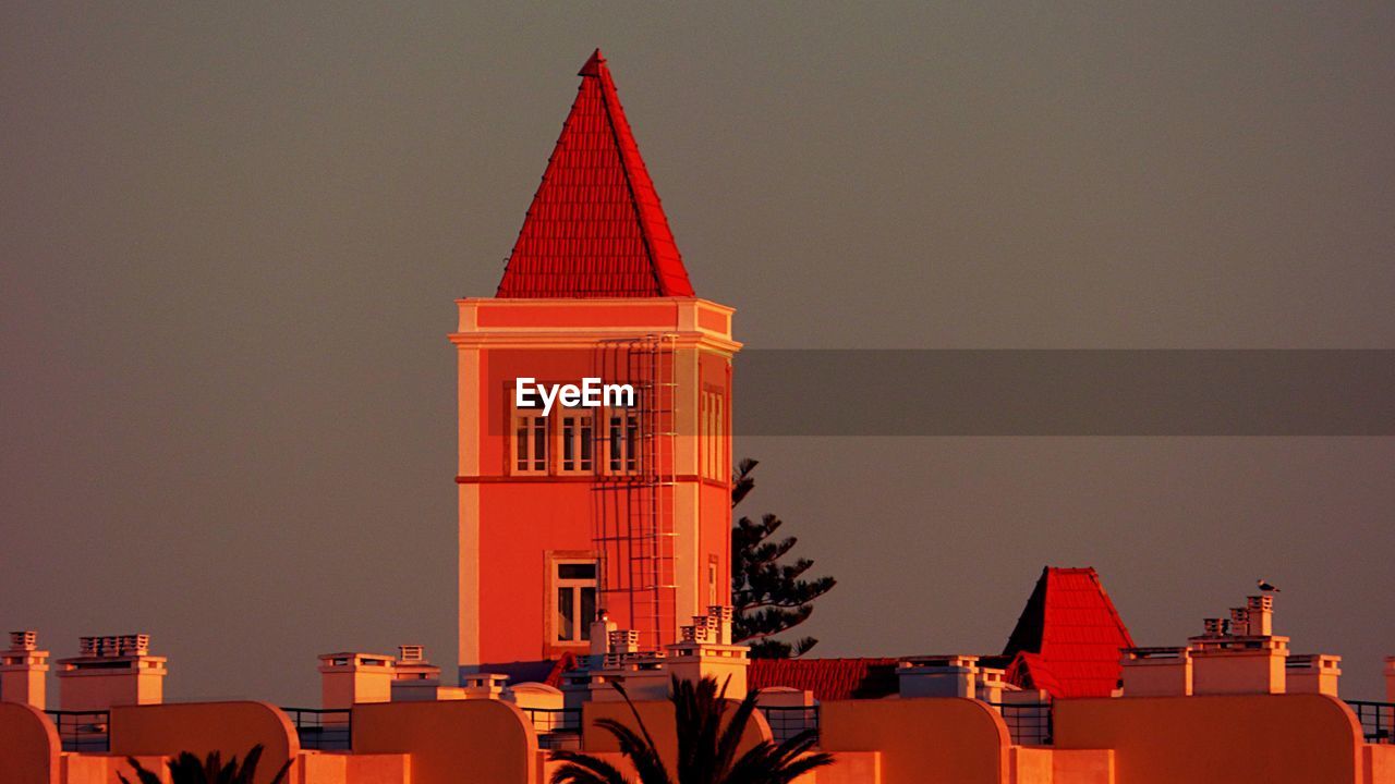 Low angle view of tower against clear sky during sunset