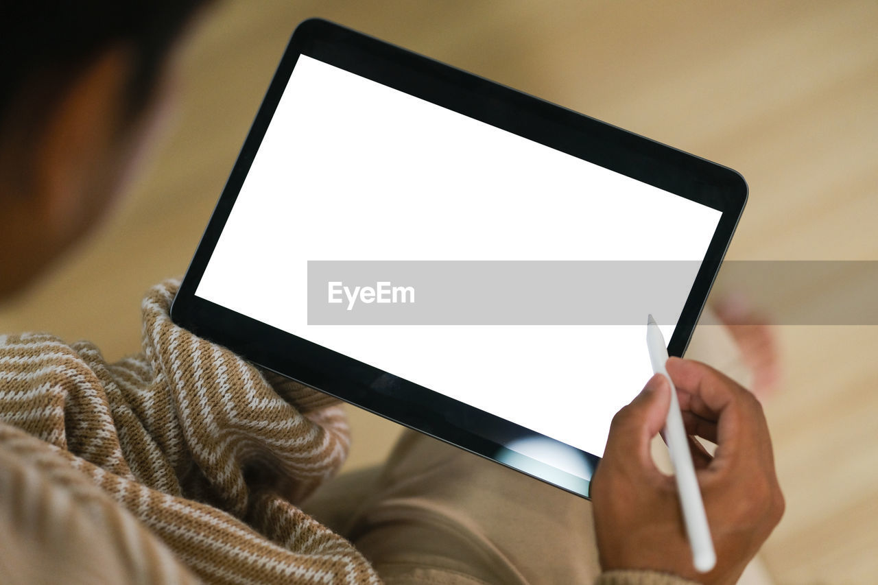 cropped hand of woman using digital tablet