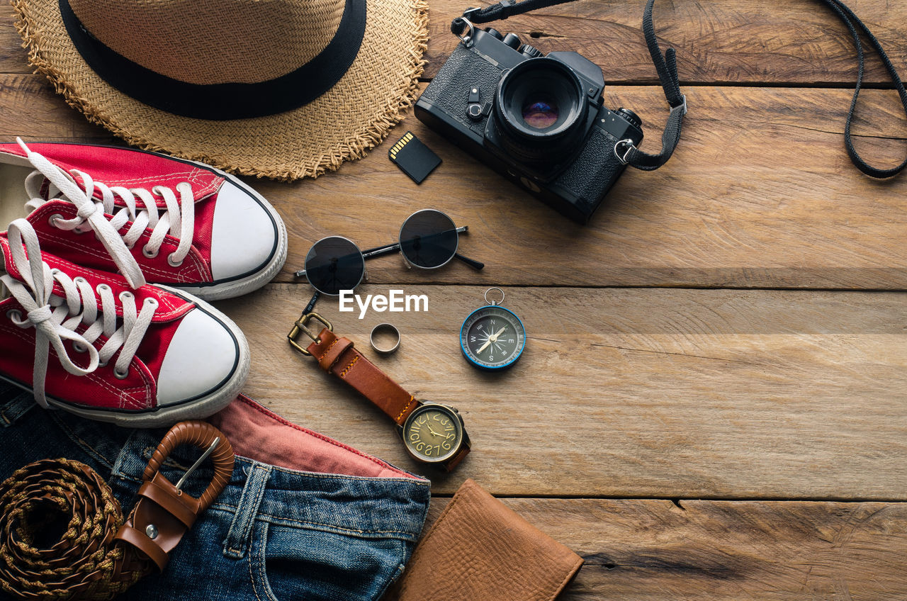 High angle view of travel objects on hardwood floor