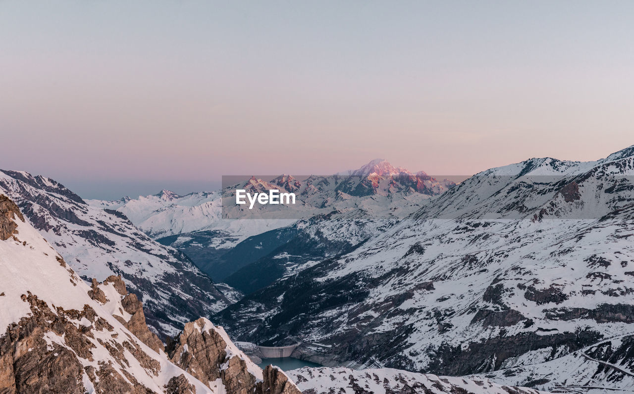 Scenic view of snowcapped mountains against clear sky during winter