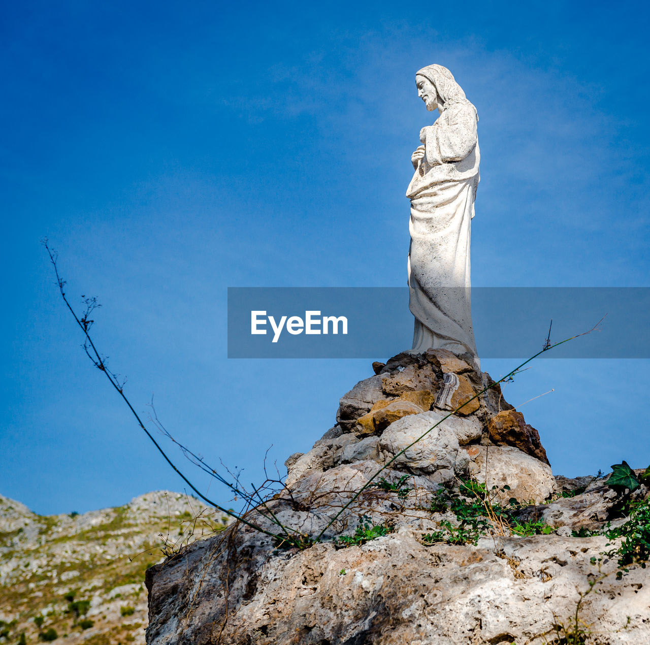 LOW ANGLE VIEW OF STATUE ON ROCK AGAINST SKY