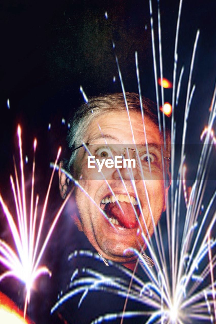 Close-up of funny mature man in front of fireworks