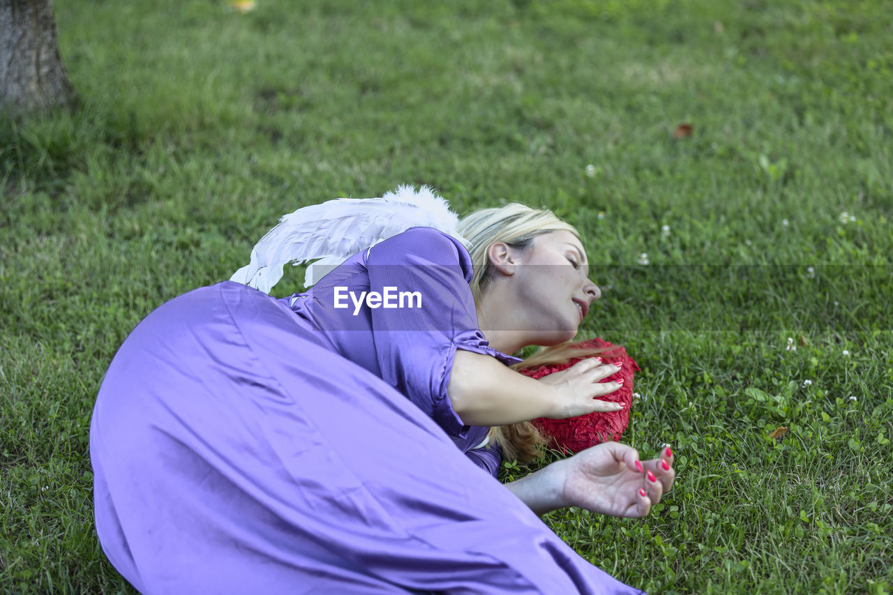 grass, one person, plant, nature, lying down, relaxation, field, women, side view, leisure activity, adult, young adult, lifestyles, day, land, person, outdoors, lawn, eyes closed, clothing, green, casual clothing, emotion, child, full length, three quarter length, looking, female, plain, childhood, blond hair, meadow