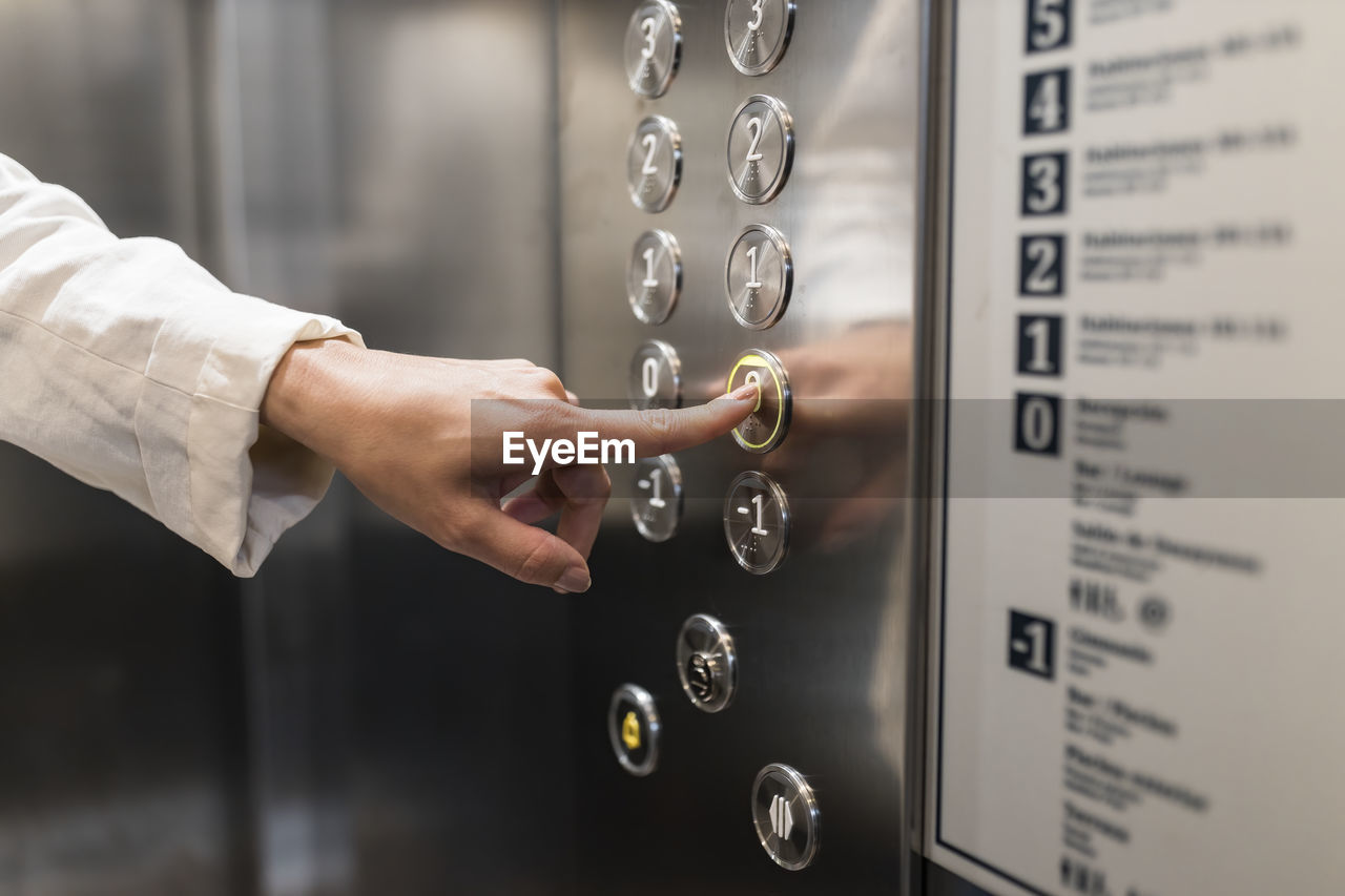 Hand of businesswoman pressing elevator button