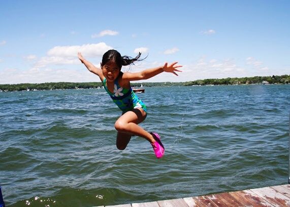 YOUNG WOMAN JUMPING IN SEA