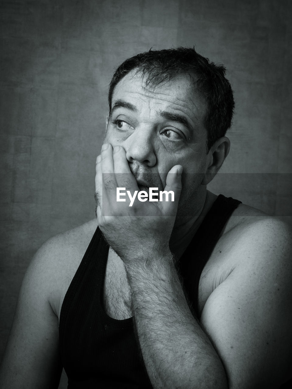 Close-up of thoughtful man looking away against wall