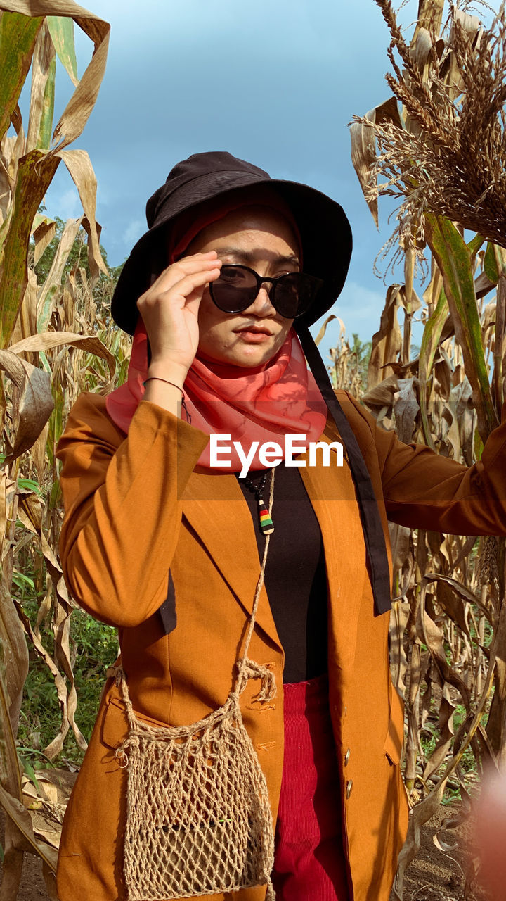 Portrait of woman wearing sunglasses while standing against sky