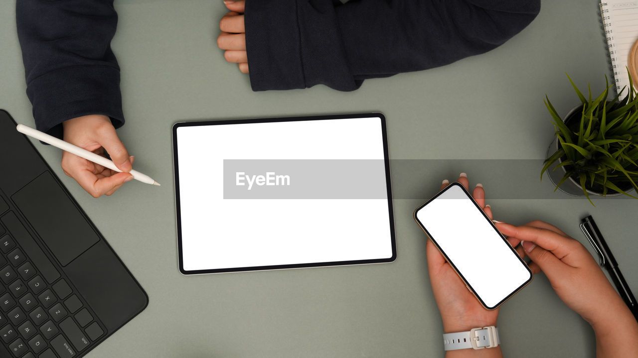 Cropped hands of woman using laptop on table