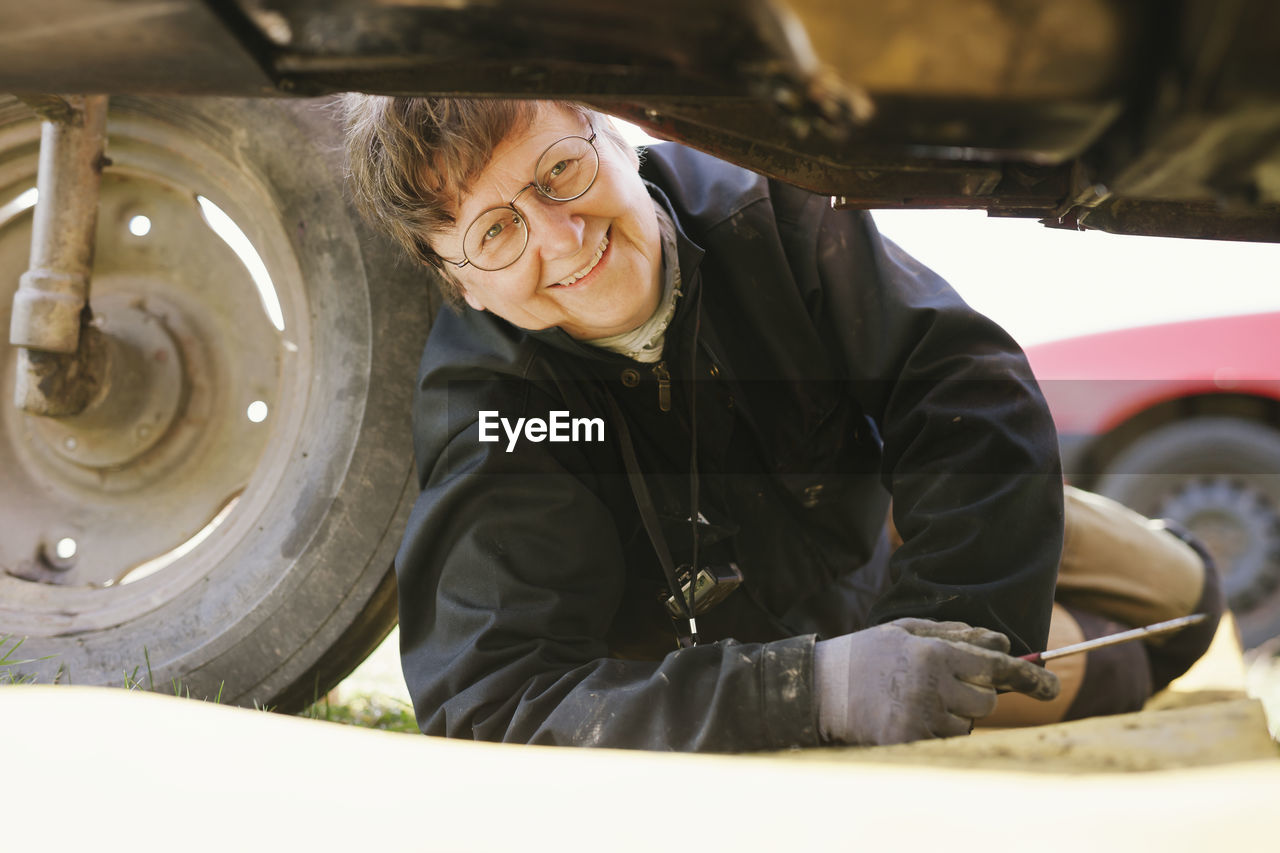 Woman repairing tractor