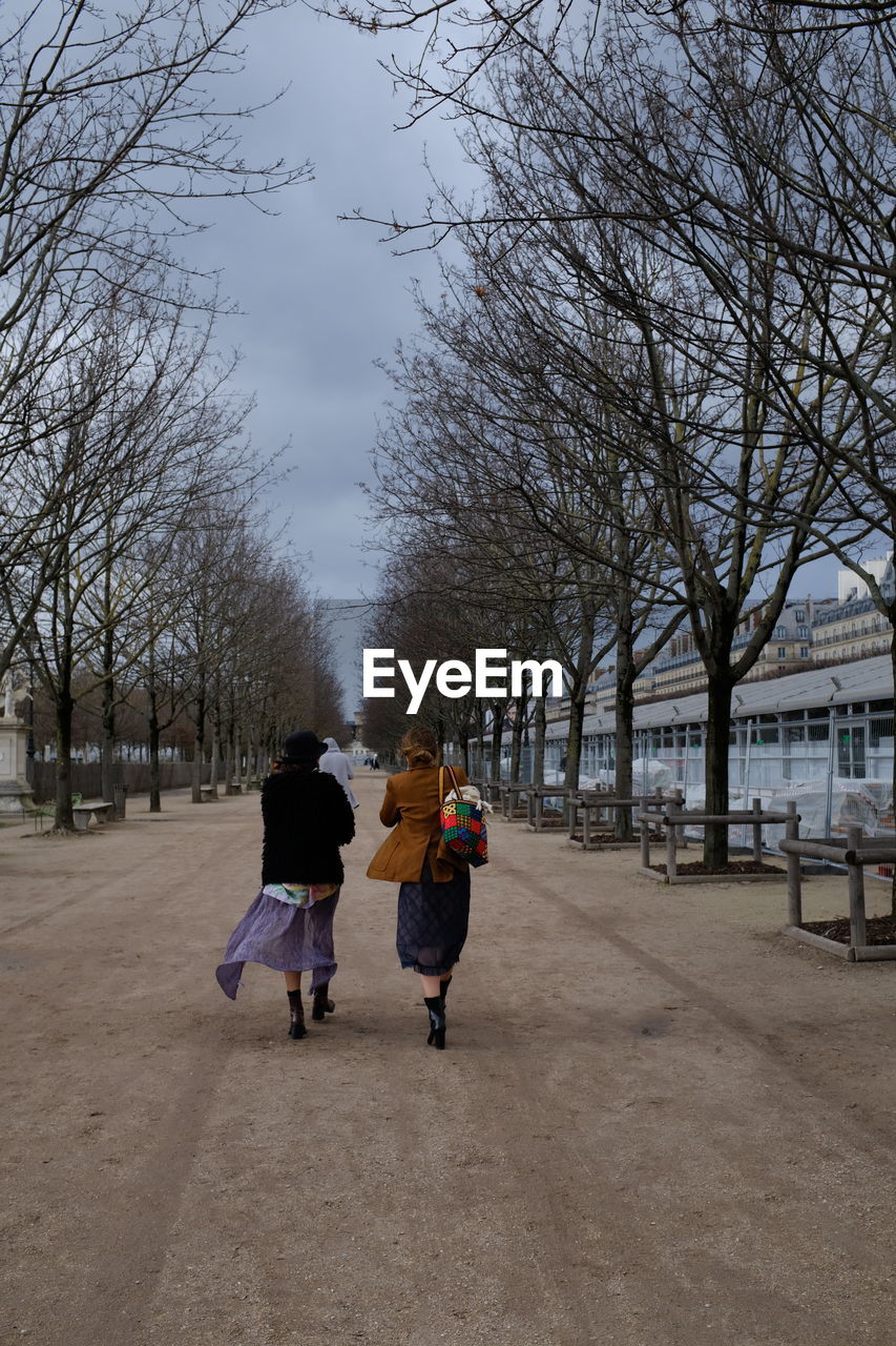 REAR VIEW OF PEOPLE WALKING ON STREET