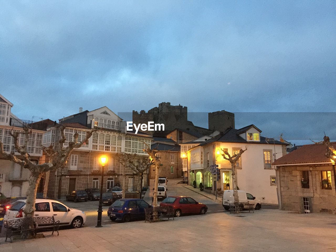 View of city street against cloudy sky