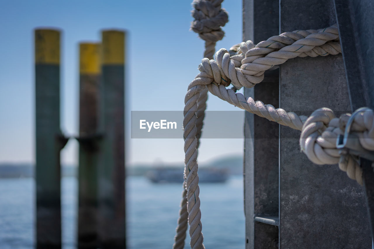 CLOSE-UP OF ROPES TIED ON WOODEN POST