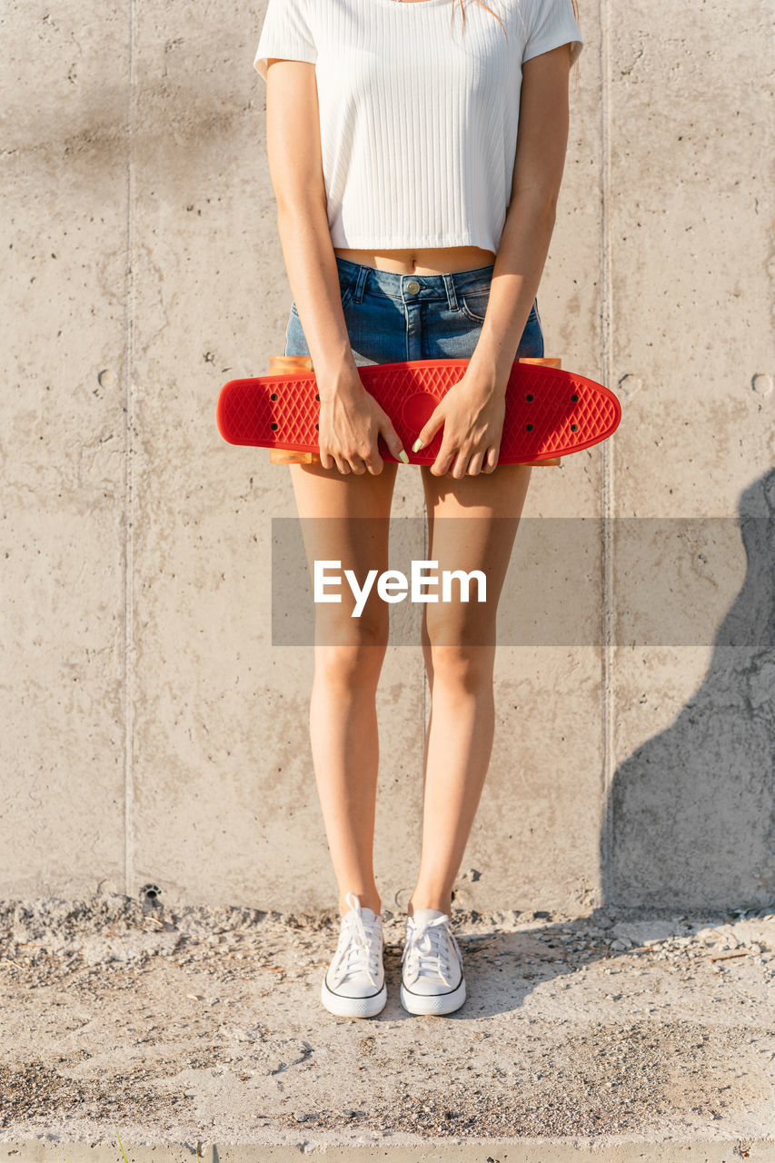 Teenage girl holding a skateboard
