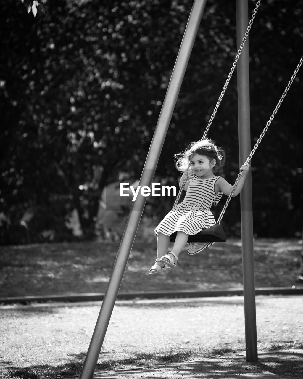 Girl sitting on swing at playground