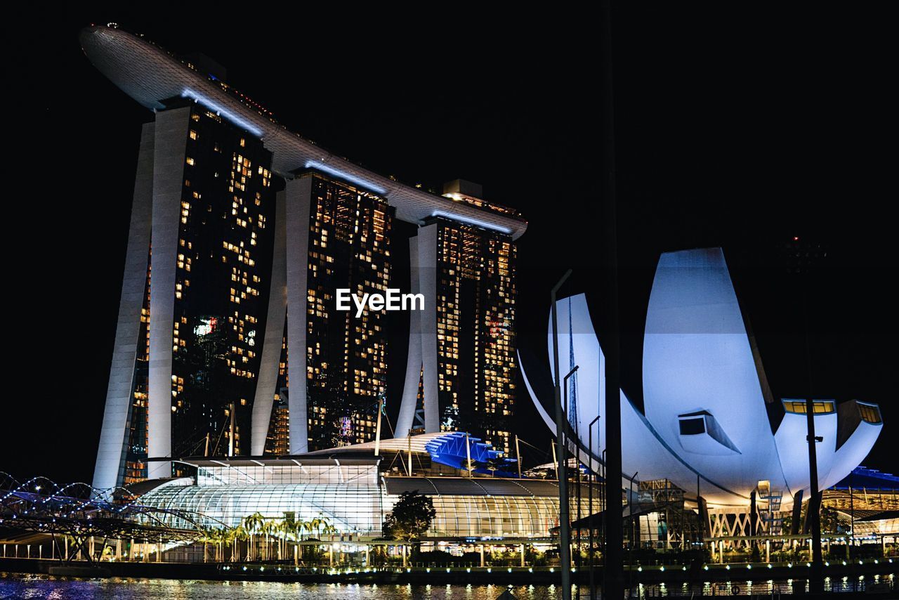 LOW ANGLE VIEW OF ILLUMINATED BUILDING AT NIGHT