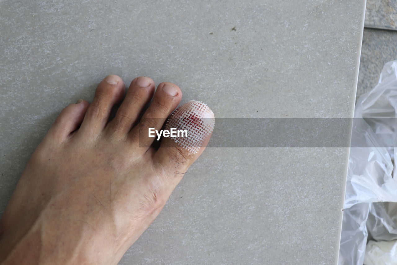 HIGH ANGLE VIEW OF MAN HAND ON BALL AGAINST WALL