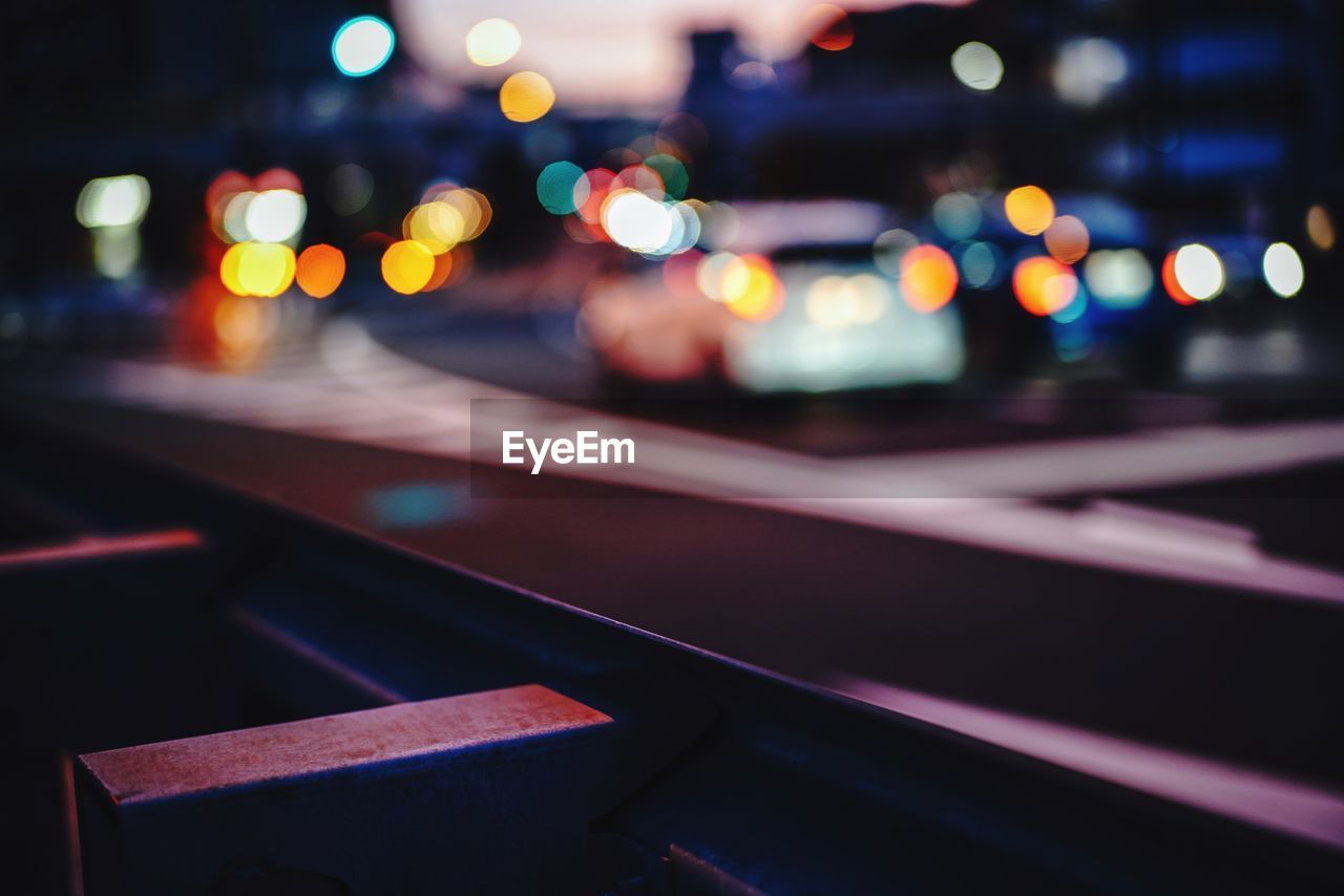 Defocused image of illuminated lights on road at night