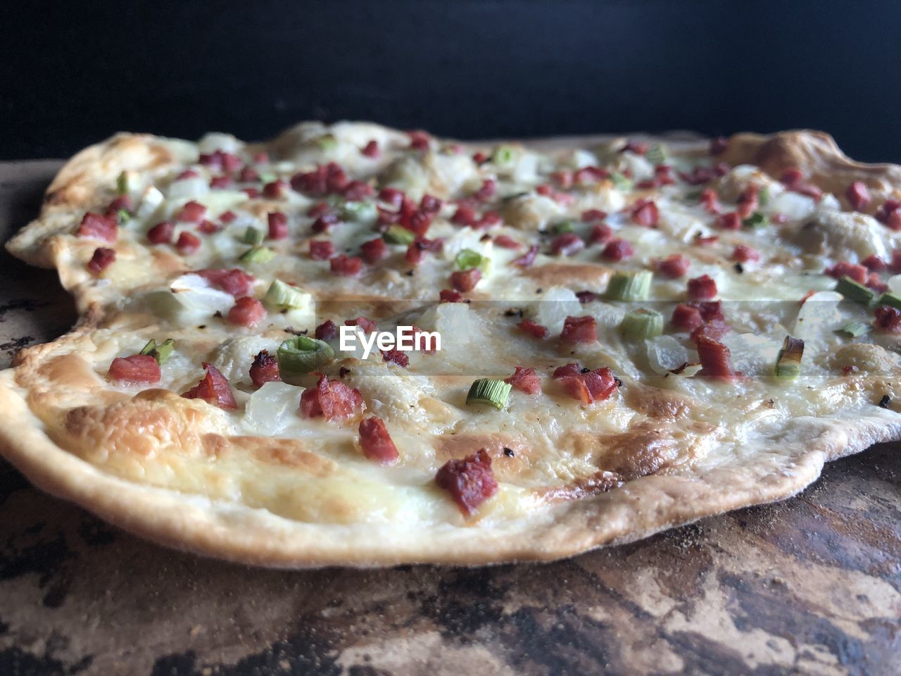 CLOSE-UP OF PIZZA SERVED ON CUTTING BOARD