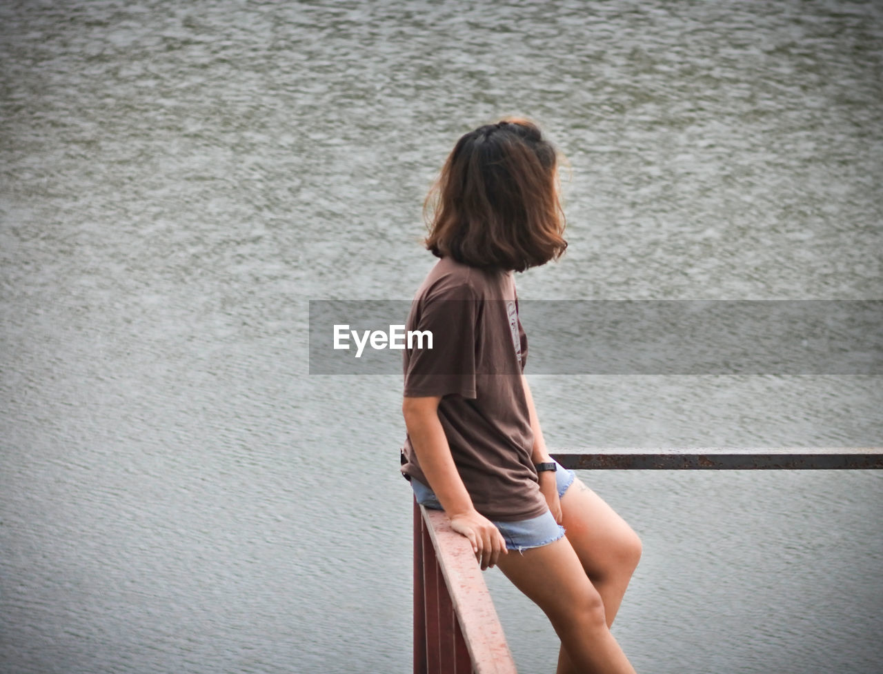 Side view of woman standing against wall