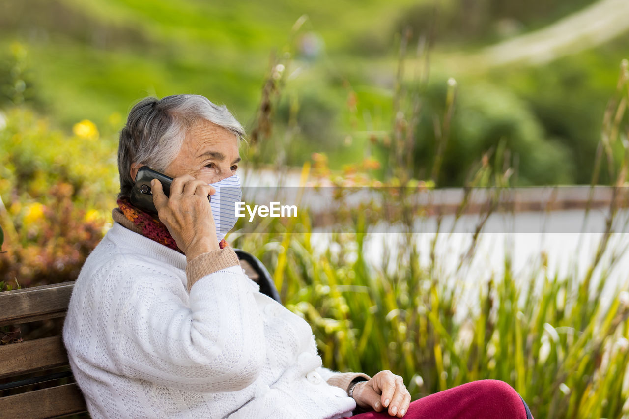 Side view of woman sitting outdoors