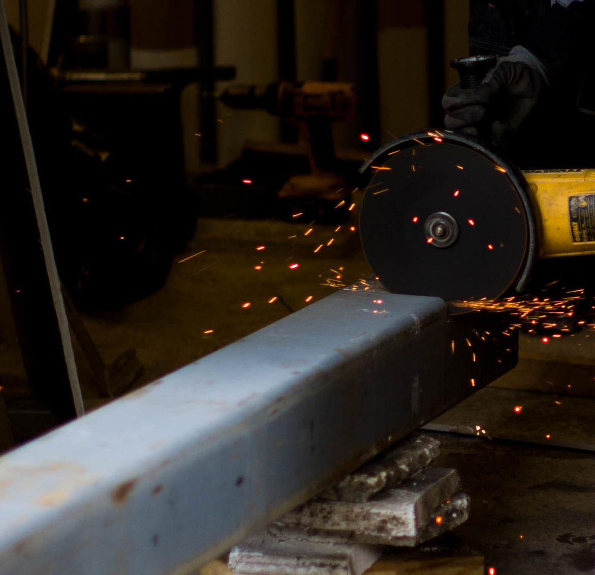 Cropped image of worker cutting metal with circular saw