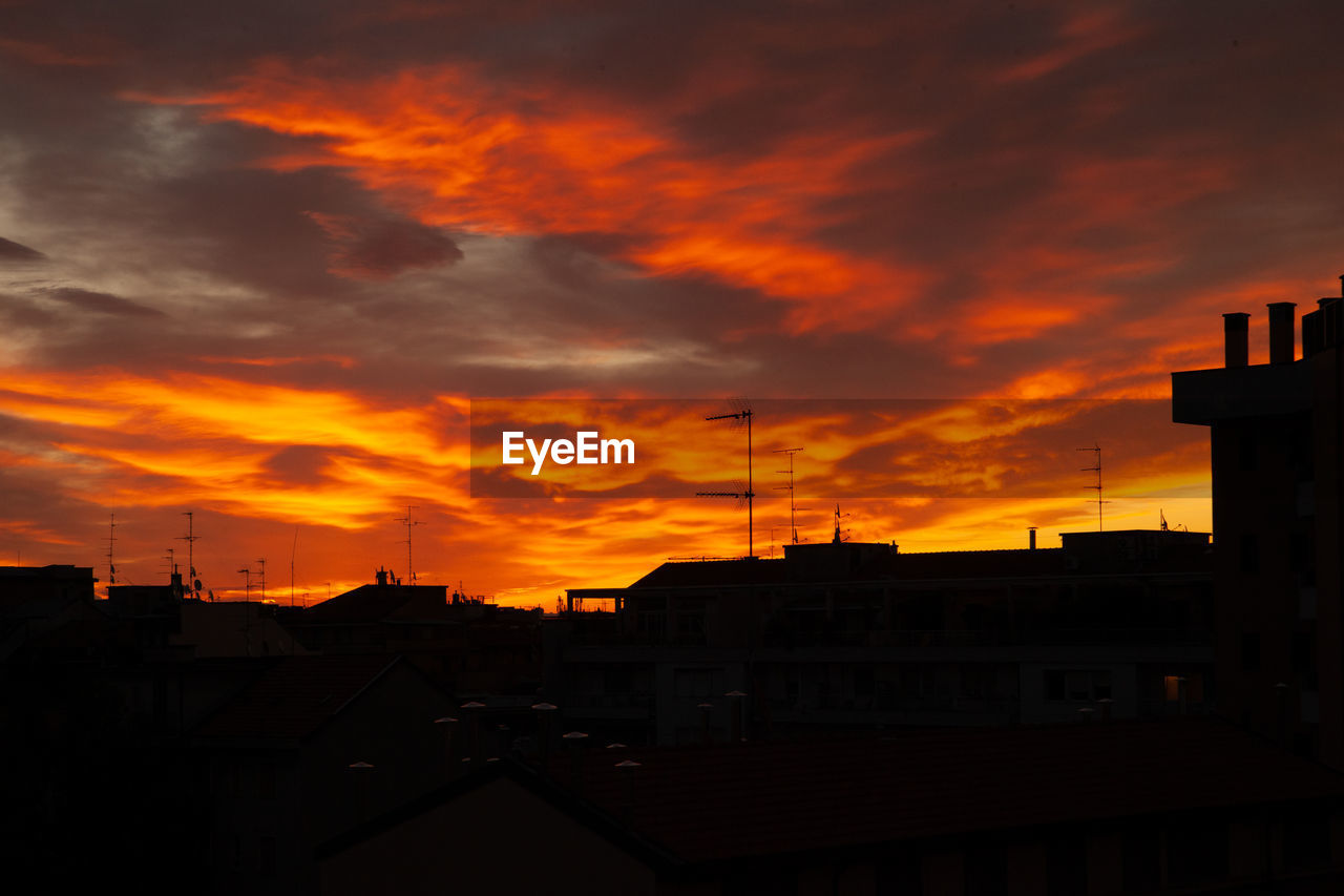 SILHOUETTE BUILDINGS AGAINST ORANGE SKY DURING SUNSET