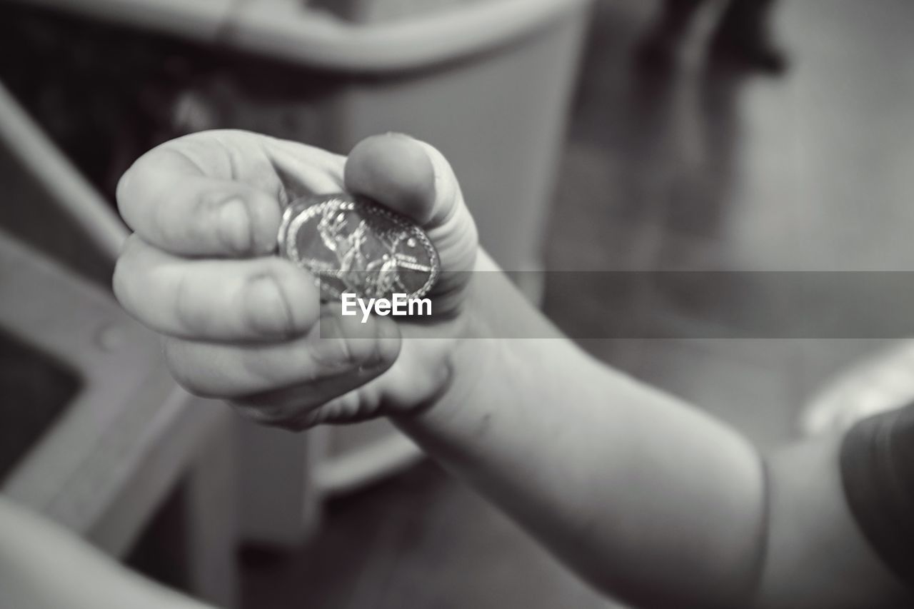 Cropped image of man holding penny