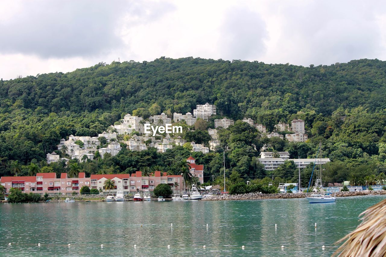 Scenic view of lake by buildings against sky