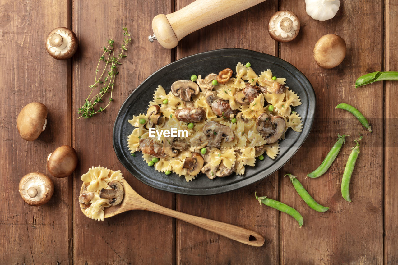 HIGH ANGLE VIEW OF MUSHROOMS IN CONTAINER ON WOODEN FLOOR