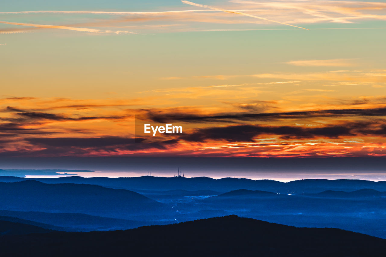 SCENIC VIEW OF DRAMATIC SKY OVER SILHOUETTE MOUNTAINS