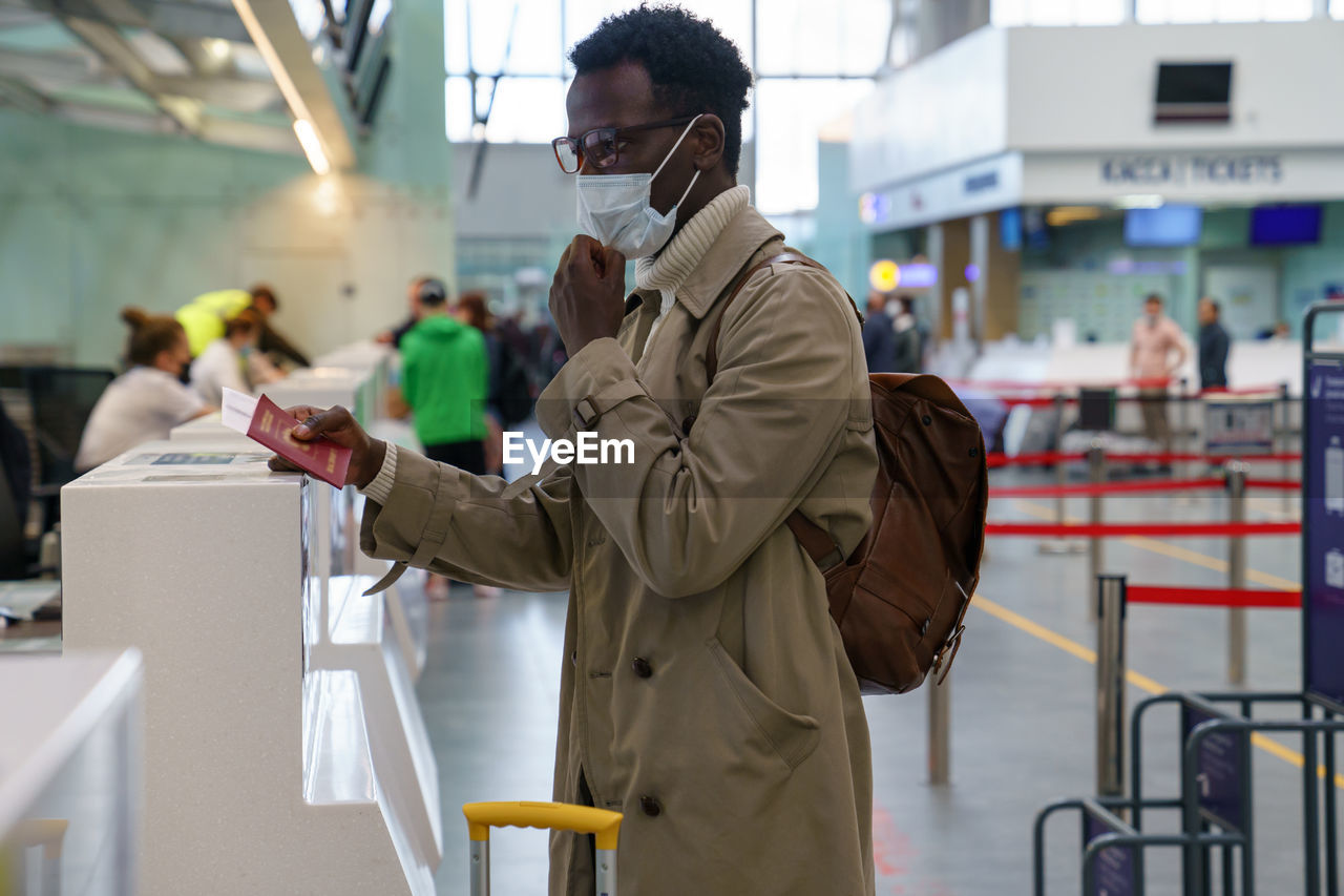 Man wearing mask while standing at airport