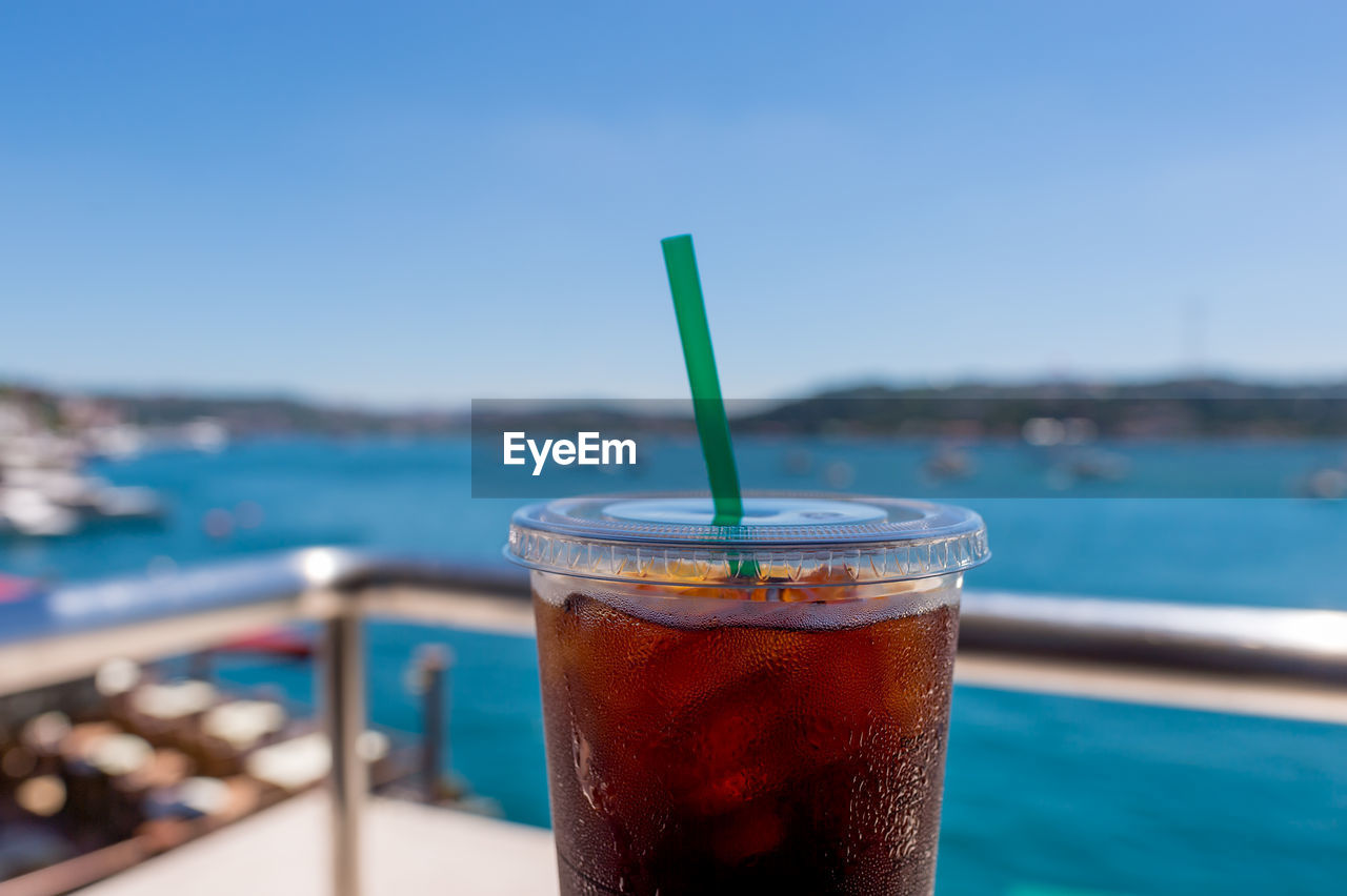 Close-up of iced coffee against sky